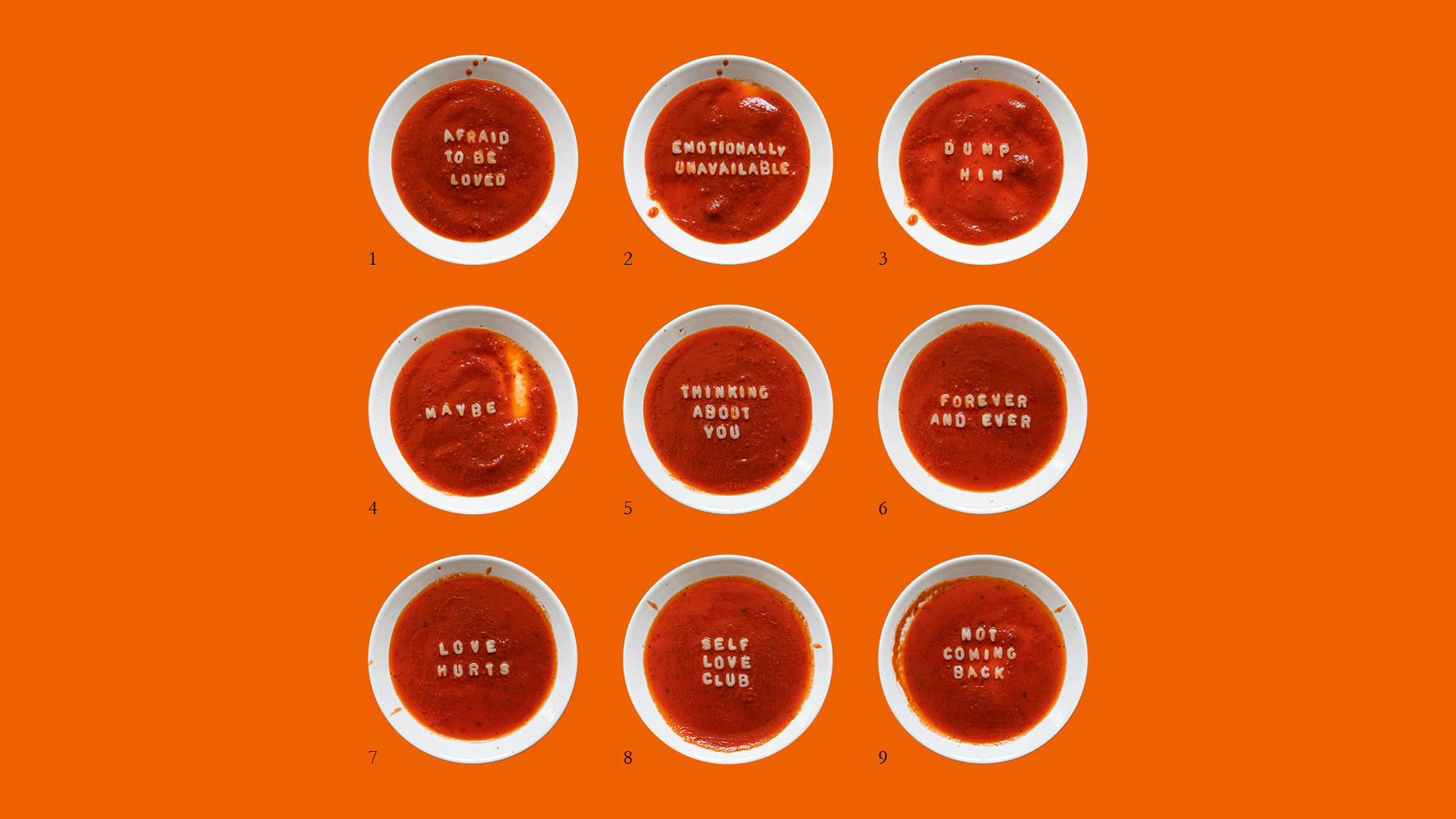Neun weiße, mit Tomatensuppe gefüllte Schalen sind in einem 3x3-Raster auf einem orangefarbenen Hintergrund angeordnet. In jeder Schale sind Worte in die Suppe geschrieben, die verschiedene Gefühle oder Sätze über die Liebe ausdrücken.