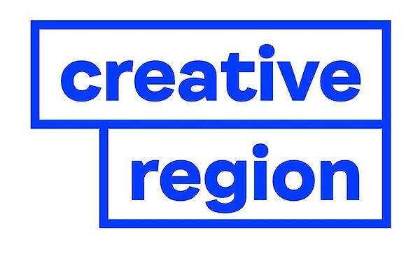 Der blaue Text "Kreativregion" wird in fetten Kleinbuchstaben dargestellt, jedes Wort in einem separaten blau umrandeten Rechteck, wobei sich die Rechtecke auf weißem Hintergrund leicht überlappen.