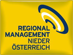 Gelbes Rechteck mit dem Text Regionalmanagement Niederösterreich in Blau, darunter ein geschwungenes, abstraktes blau-weißes Symbol, das Schallwellen oder einer stilisierten Spirale, ebenfalls in Blau, ähnelt.